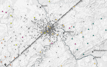 Landkarte der Eifelregion im Westen Deutschlands, in Grautönen gehalten. Es sind einige Städte eingezeichnet: Köln und Maastricht im Norden, wie Frankfurt im Osten, Koblenz im Süden. Viele kleine Dreiecke zeigen, wo die Messstationen aufgestellt waren. Viele waren entlang einer Kette von Nord-Ost bis Süd-West ausgerichtet.