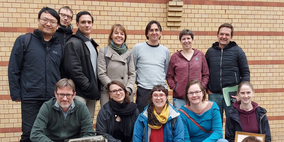 Group photo Scientific Council at the GFZ, 14 people, brick wall in the background