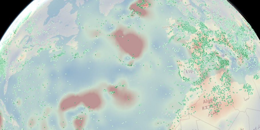A circular section of the world map with bright red, green and blue areas. On the left is America with lots of small green dots; in the centre is the Atlantic Ocean with scattered small green dots; on the right are Europe, Africa and Asia with a high density of small green dots.
