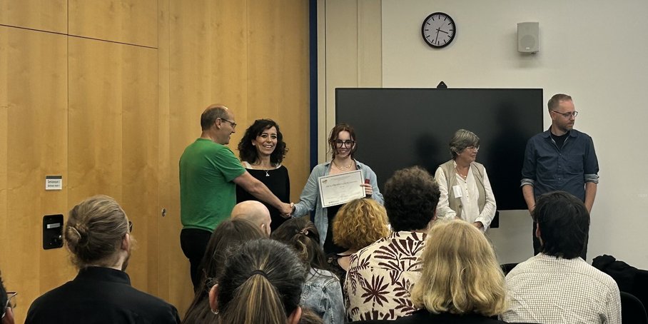 Max Wilke and Hella Wittmann-Oelza handing over the "best talk" award to Candice Filoche
