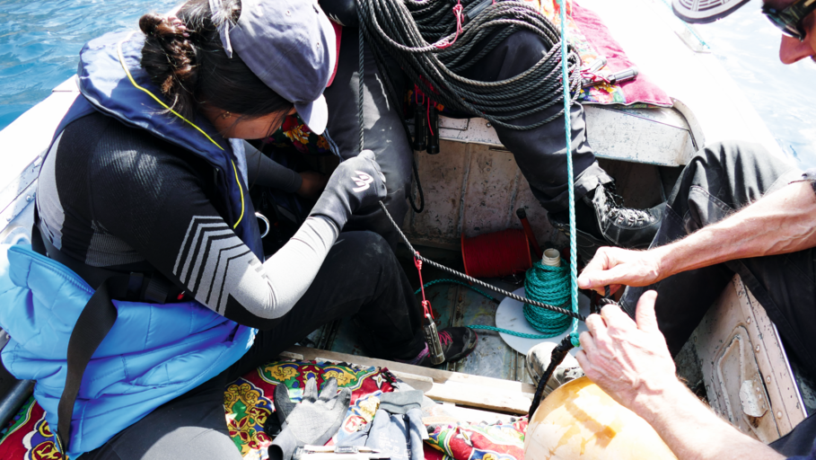 Scientists are changing floating sensors in boat on lake.