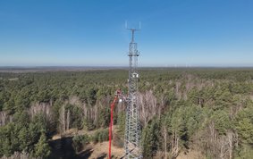 Panoramic view of a radio tower in a wooded landscape