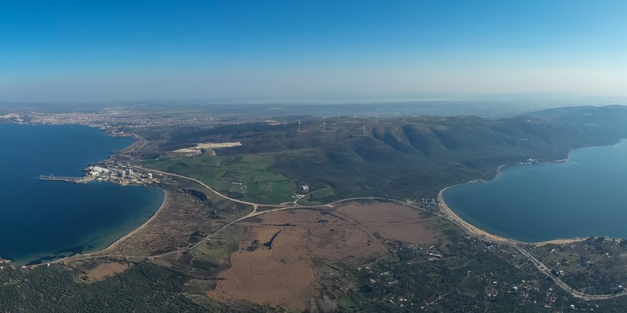 Aerial view from a height of approx. 500m. View of the peninsula from the mainland. The narrow passage in the middle, the sea to the right and left and the peninsula on the horizon. Blue sky above.