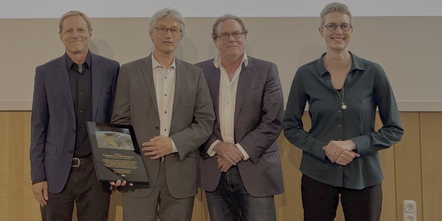 Einfacher Gruppenbild vor einer Wand von vier Personen frontal