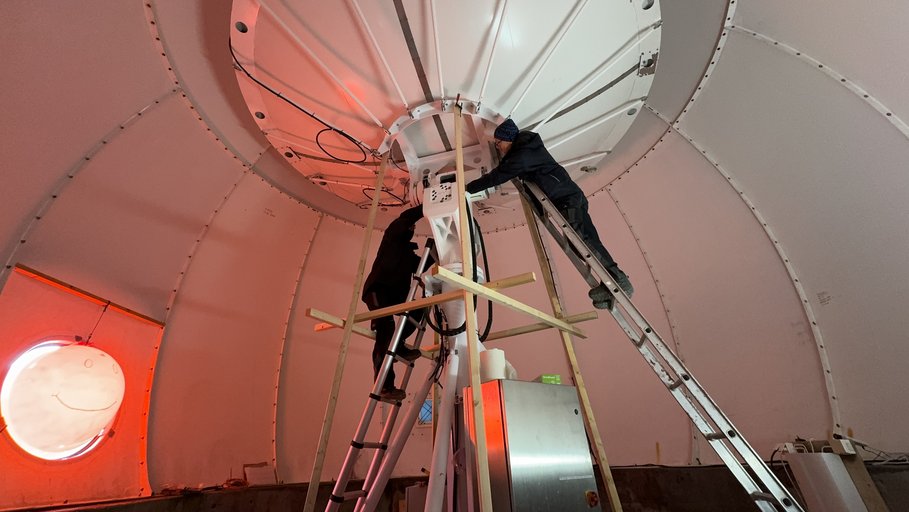 Innenraum einer Satelliten-Empfangsstation; auf Leiter warten Wissenschaftler die Antennen.