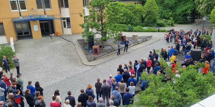 Alternativtext: Die neue Vorständin steht neben dem Pressesprecher, umrundet von rund 100 Mitarbeitenden des GFZ. Im Hintergrund das Gebäude und das Säulenforum.