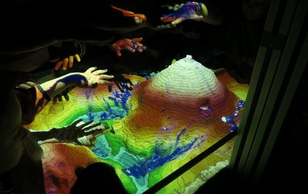 Sandberg mit Kinderhänden