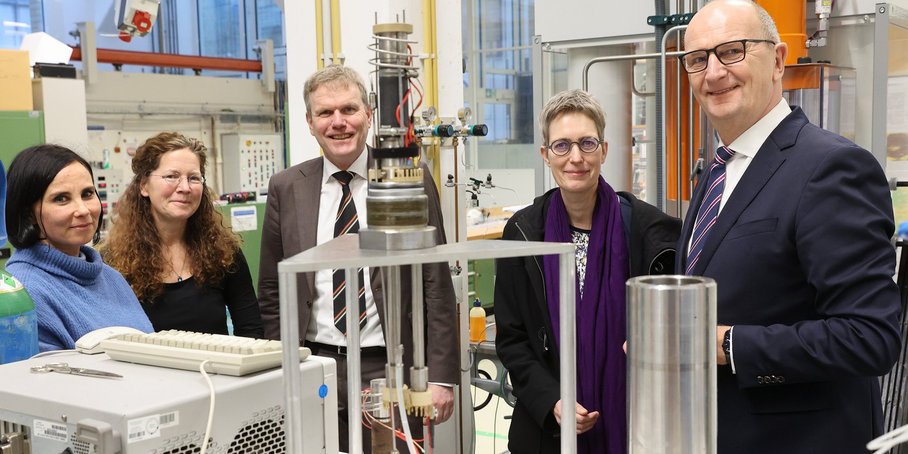 5 persons standing in a Lab between experiments.