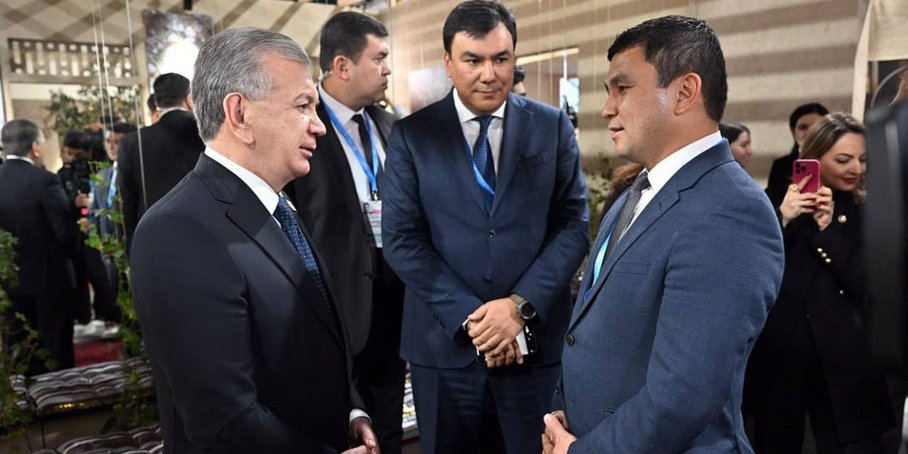 Dr Abror Gafurov (right) standing in a semi-circle in conversation with the Uzbek presidents and another person at COP29. There are other people in the room.