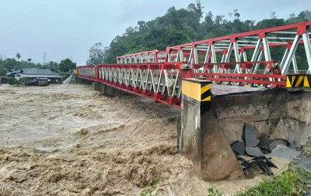[Translate to English:] Metallbrücke, die zum Teil gebrochen ist und durch die ungewöhnlich viel schlammiges Wasser fließt