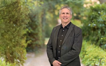 Portrait of Wolfgang zu Castell outside at GFZ, plants in the background
