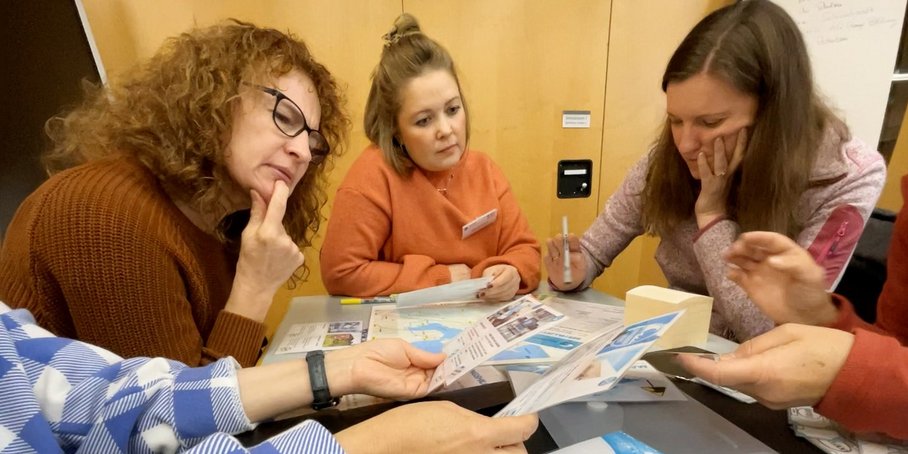 Workshop photo with several participans around a flyer.
