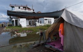 Folgen des Tsunamis in Indonesien_Boot lagert auf einem Haus, davor eine provisorische Behausung