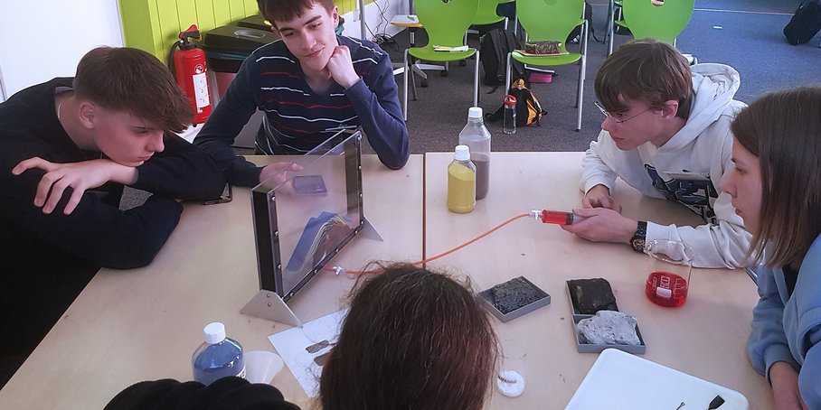 [Translate to English:] Kinder die an einem Tisch Experimente machen