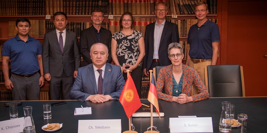 Gruppenfoto der Teilnehmenden in der historischen Bibliothek, zwischen historischen Büchern und Möbiliar.