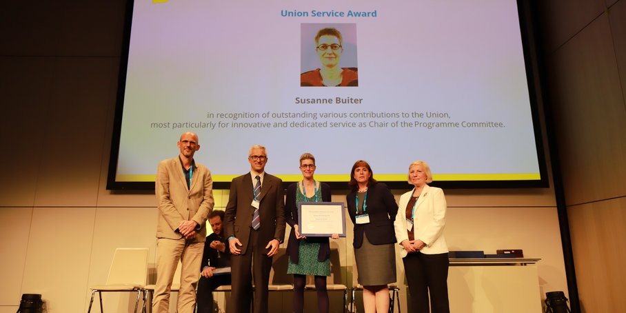 5 people at the EGU in front of a screen. Susanne Buiter holds the price.