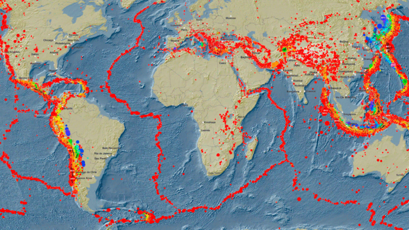 World map with countless red dots marking the locations of earthquakes. They are mainly concentrated along the boundaries of the continental plates, resulting in linear patterns.
