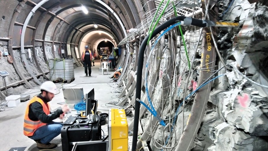 Auf dem Bild ist ein Tunnel abgebildet mit einem Forscher, welcher Kabel legt
