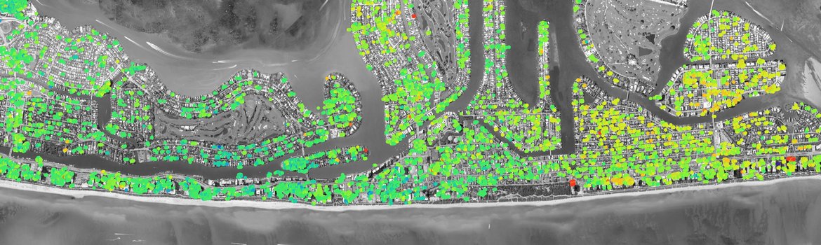 Ein Satellitenbild von Miami Beach mit den Barriereinseln und Gebäuden mit grünen, gelben und roten Punkten, die Verschiebungsmessungen anzeigen.