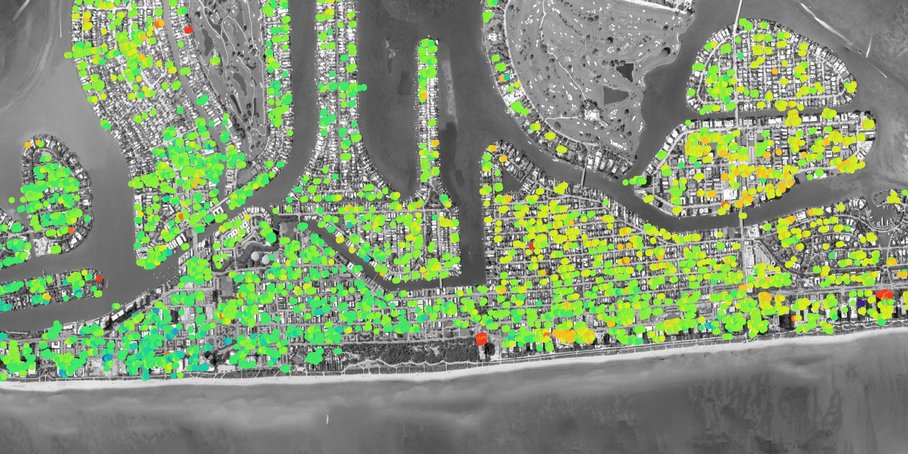 Ein Satellitenbild von Miami Beach mit den Barriereinseln und Gebäuden mit grünen, gelben und roten Punkten, die Verschiebungsmessungen anzeigen.