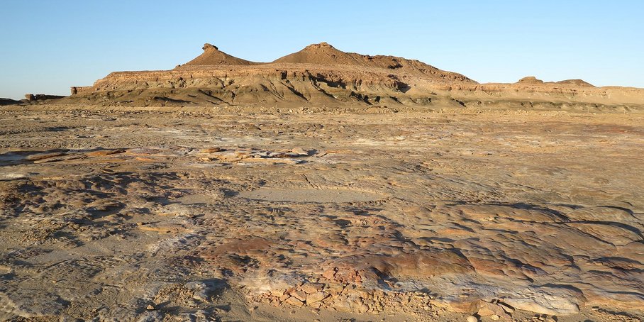 Dried-up desert lake on the Arabian Peninsula with mountain range in the background