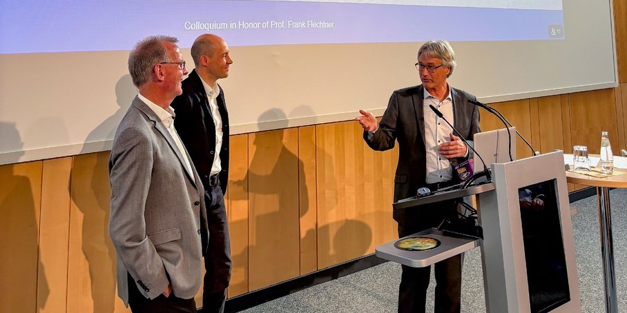 3 Herren vor einer Leinwand